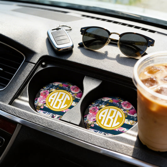 a car's center console with a pair of sunglasses, a key, and a drink in a cup.