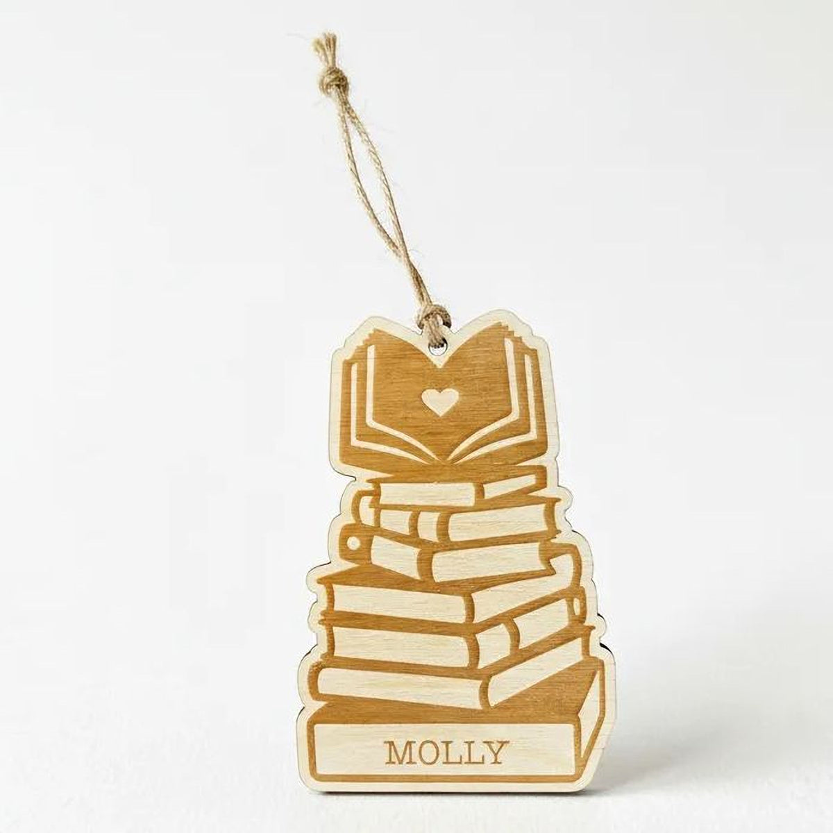 A wooden ornament with a stack of books and a heart symbol, hanging from a string.