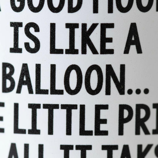a close-up view of a textured surface with the phrase "A GOOD FOOD IS LIKE A BALLOON... E LITTLE PRINCE" printed on it.