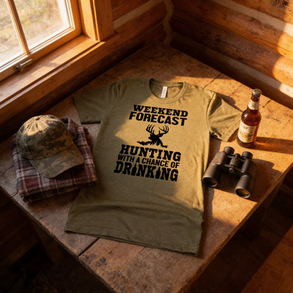 A t-shirt with a humorous text printed on it, along with a pair of binoculars and a bottle of beer, all placed on a wooden surface.