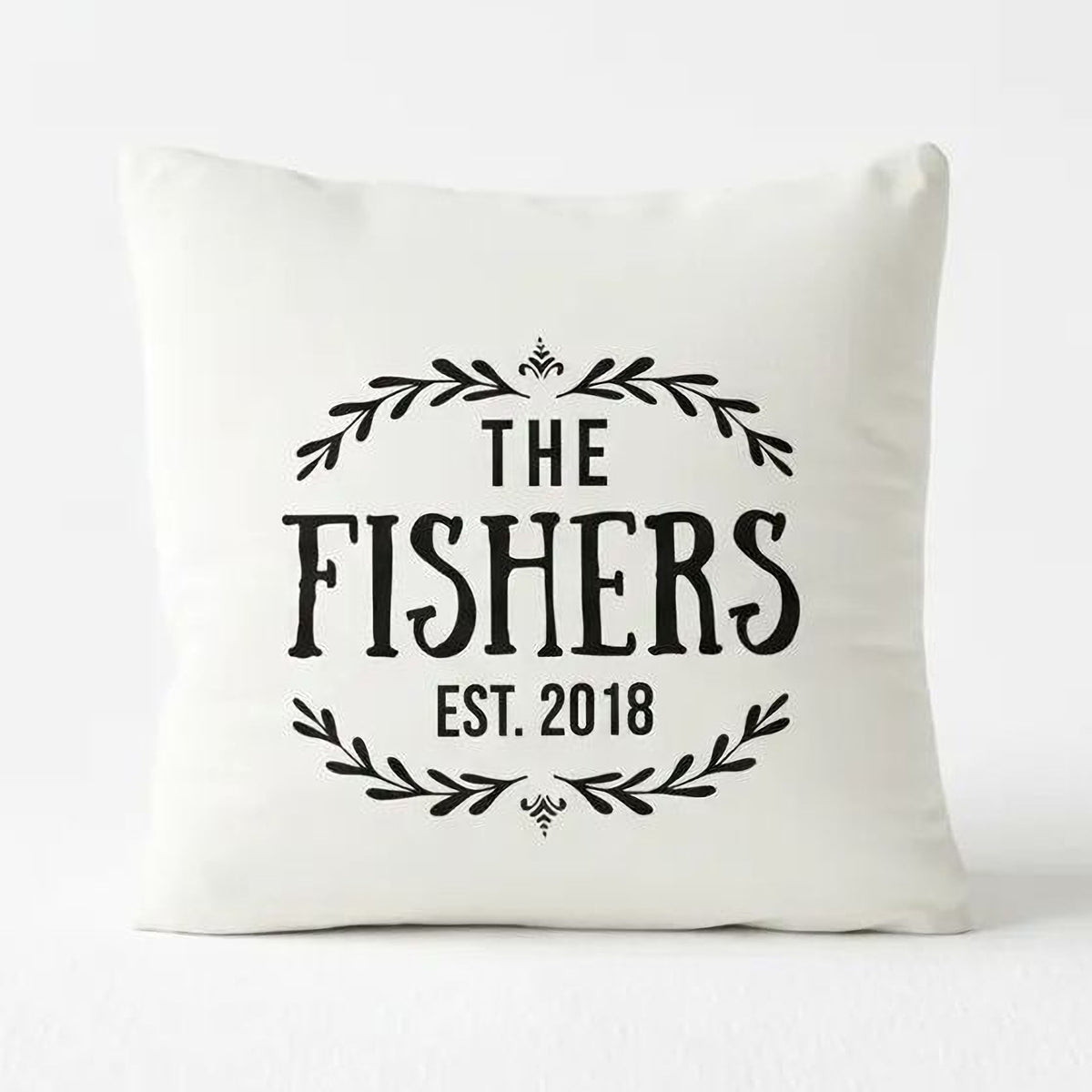 A white pillow with black text and decorative elements.