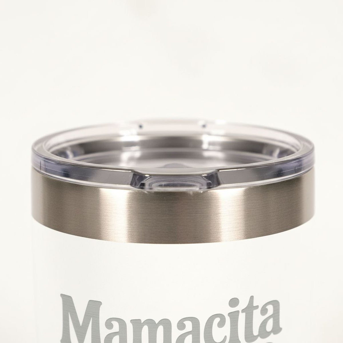 A close-up view of a stainless steel thermos lid with the word "Mamicia" printed on it.