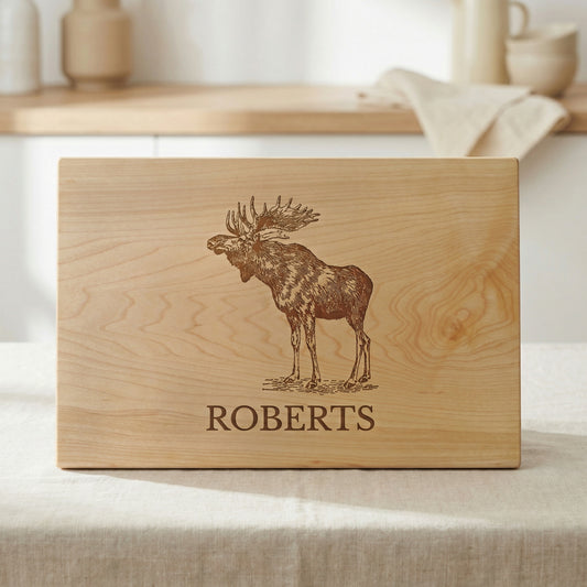 A wooden cutting board with a moose engraved on it, and the name "ROBERTS" printed below the moose.