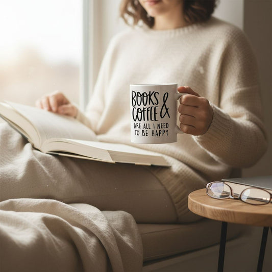 A person is sitting on a bed, holding a mug with the text "Books & Coffee are all I need to be happy" while reading a book.