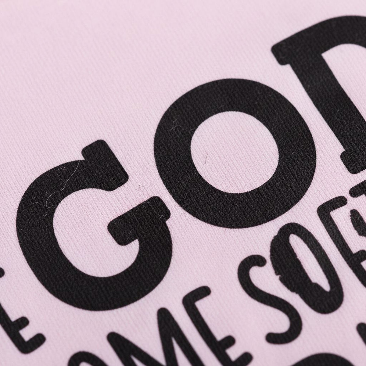 a close-up view of a pink fabric with bold black text printed on it.