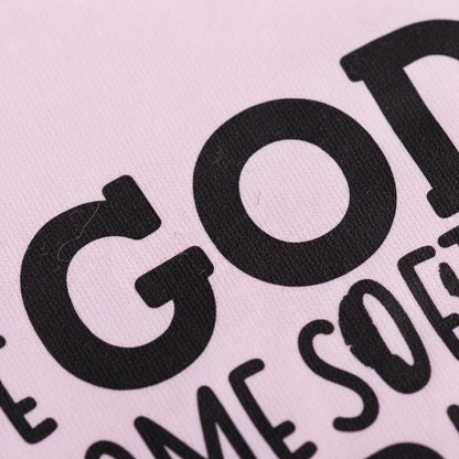 a close-up view of a pink fabric with bold black text printed on it.