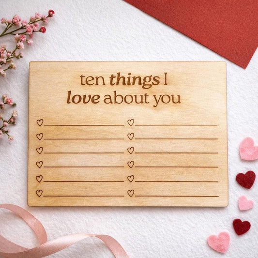 a wooden card with a list of things someone might love about another person, along with a list of hearts and a ribbon.