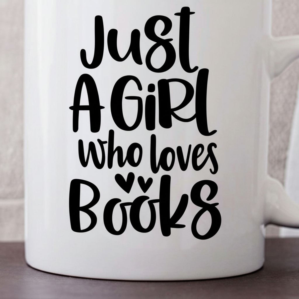A white mug with black text that reads "Just a girl who loves books".