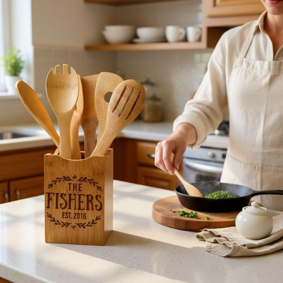 A wooden spoon holder with a person cooking in the background, and a white teapot on a wooden cutting board.