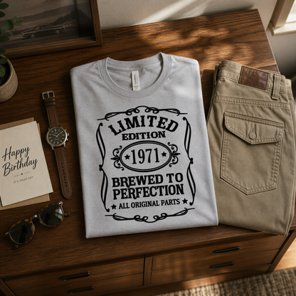 a collection of items, including a t-shirt with a printed design, a pair of khaki pants, a watch, sunglasses, and a birthday card.