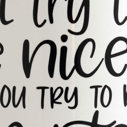 a close-up view of a white surface with black text that reads "TRY TO BE A NICE PERSON".