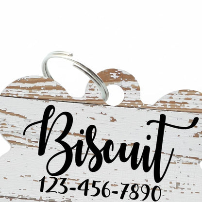 A white wooden sign with the word "Biscuit" written on it, along with a phone number.
