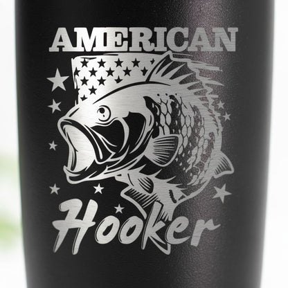 a black tumbler with a silver design of a fish and stars, along with the text "American Hooker" printed on it.