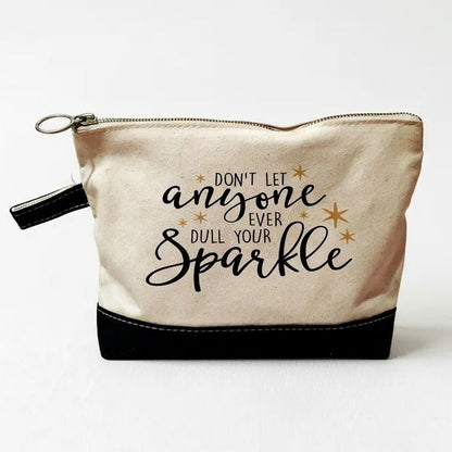 A beige and black cosmetic bag with a zipper closure and a motivational quote printed on it.