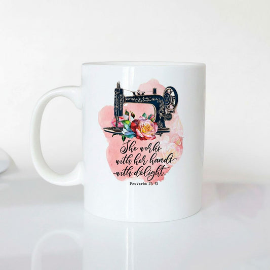 A white ceramic mug with a printed design featuring a sewing machine and flowers, along with a Bible verse from Proverbs 3:5-13.