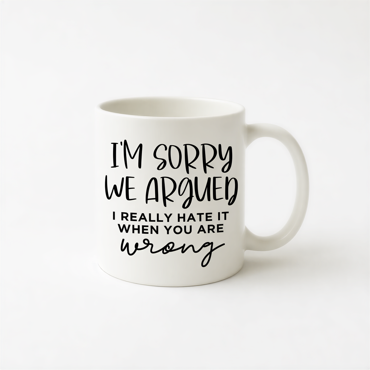 A white ceramic mug with black text that reads "I'm sorry we argued, I really hate it when you are wrong".