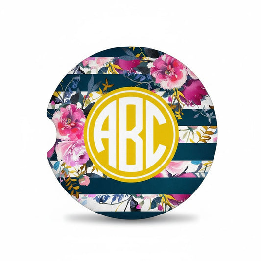 A round car seat cover with a floral design and a monogrammed letter "A" in the center.