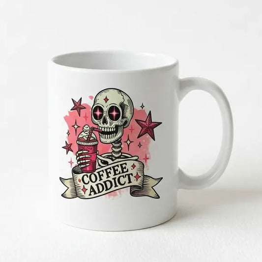A white ceramic mug with a graphic design featuring a skull holding a coffee cup, surrounded by stars and a banner that says "COFFEE ADDICT".