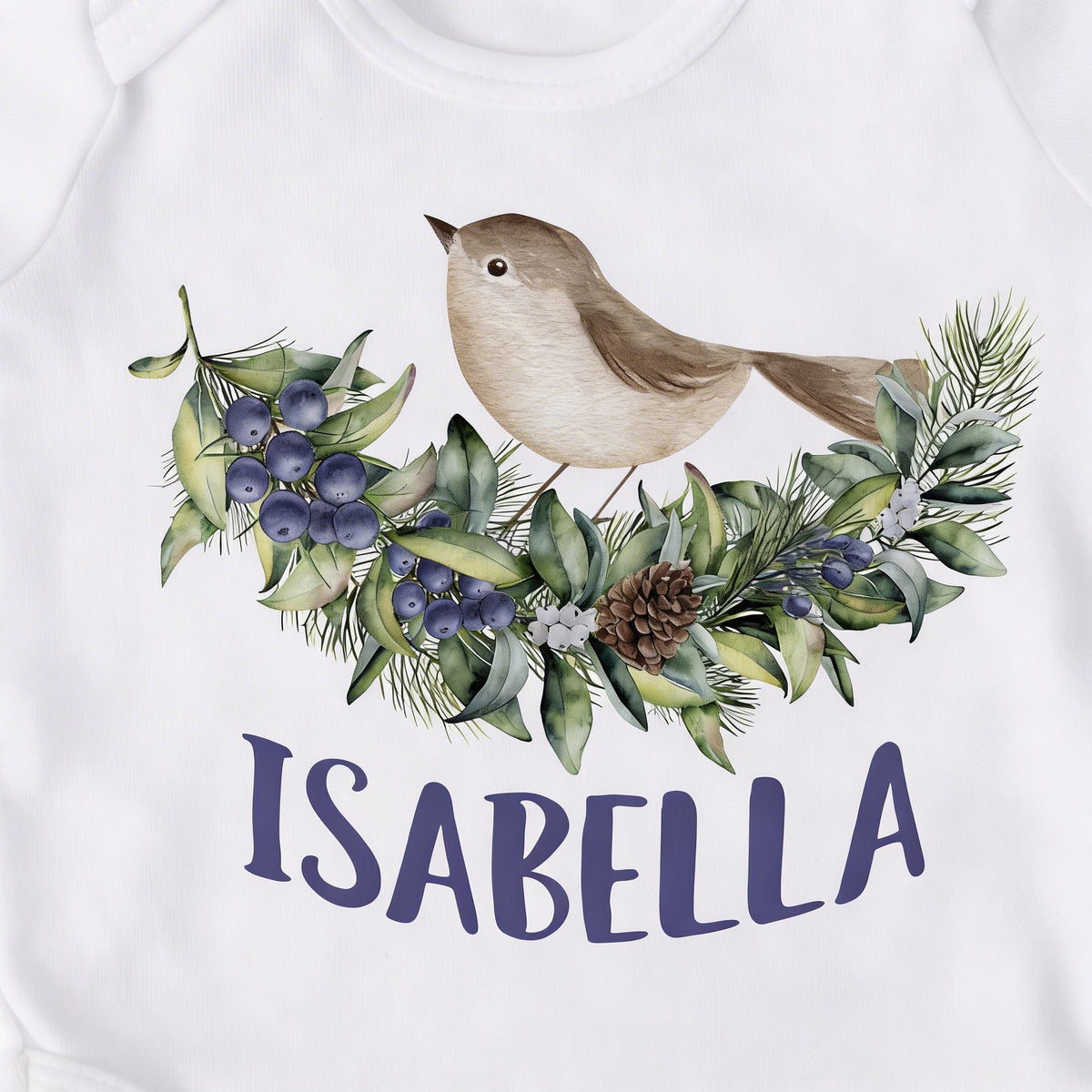 A white t-shirt with a printed design of a bird perched on a branch with berries and pine needles. The name "ISABELLA" is written below the design.