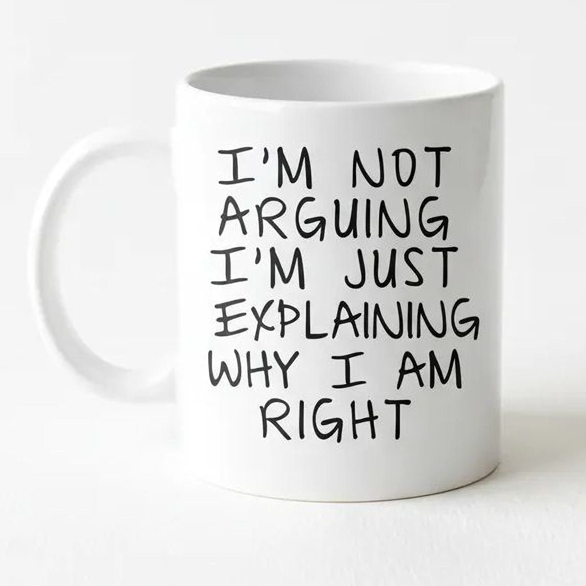 A white ceramic mug with black text printed on it.