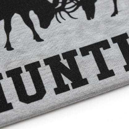 A close-up view of a grey fabric with a black silhouette of a deer and the word "HUNT" printed on it.