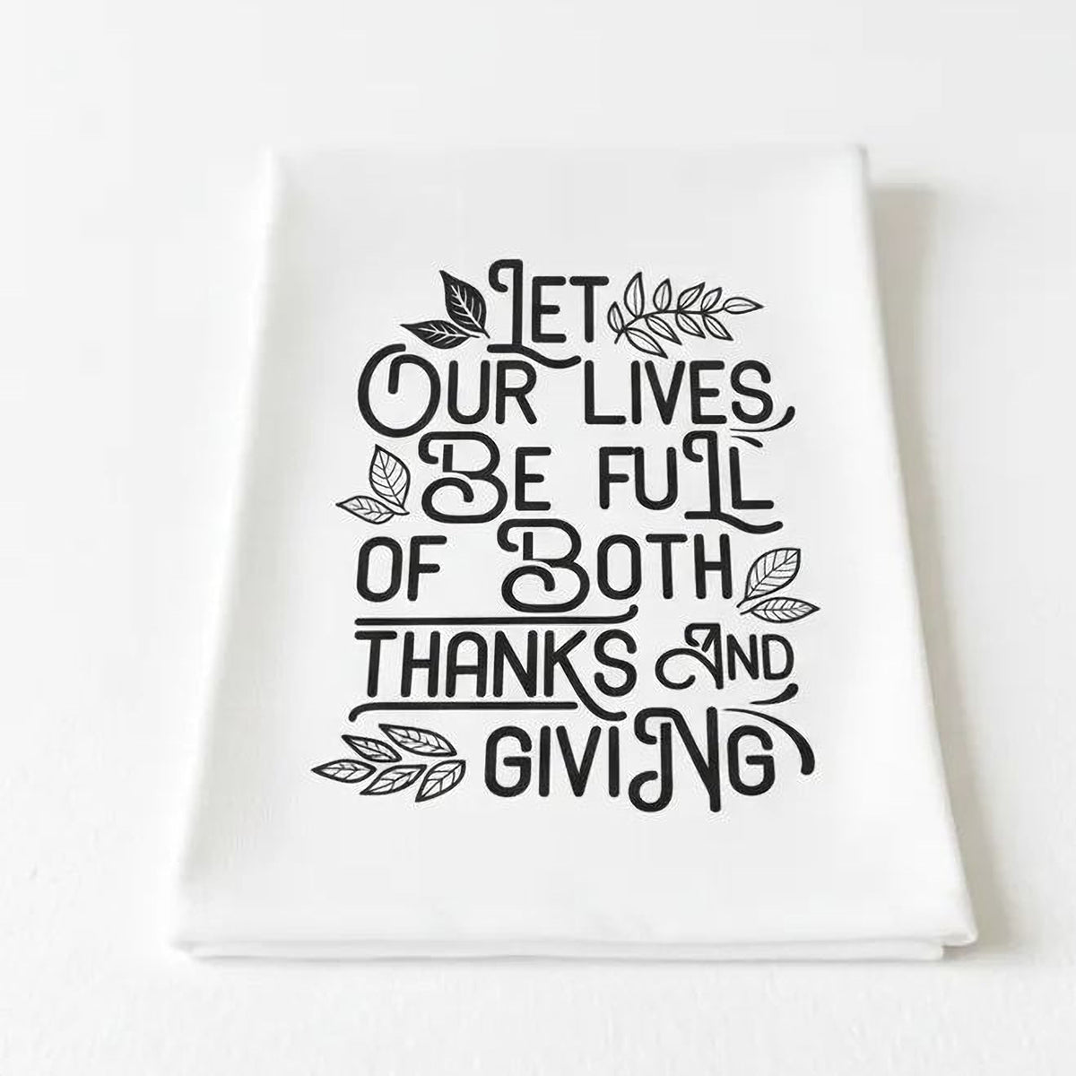 a white towel with a black and white text design that reads "Let our lives be full of both thanks and giving".