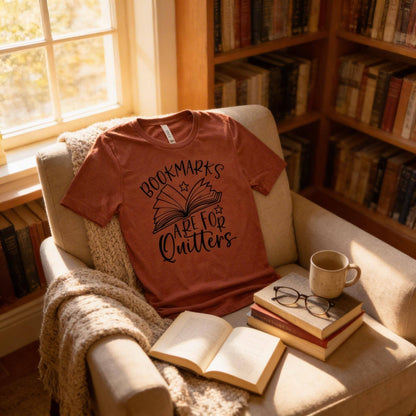 A cozy scene with a red t-shirt on a beige armchair, a stack of books, a mug, and a pair of glasses, all bathed in soft light from a nearby window.