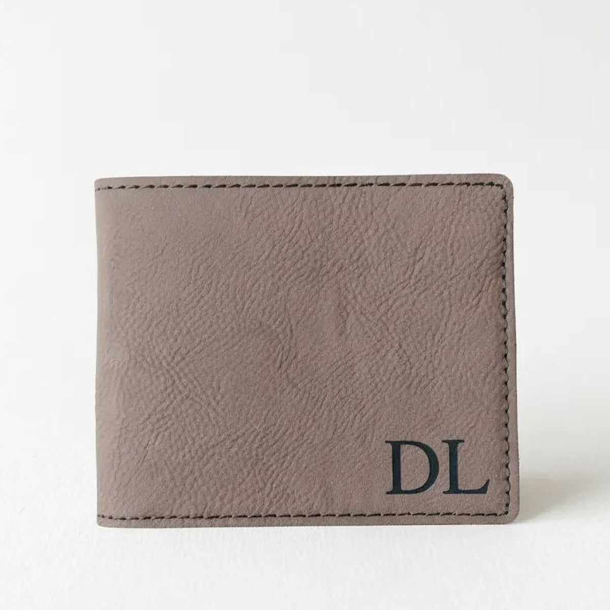 A brown leather wallet with a personalized monogrammed initials "DL" on the front.