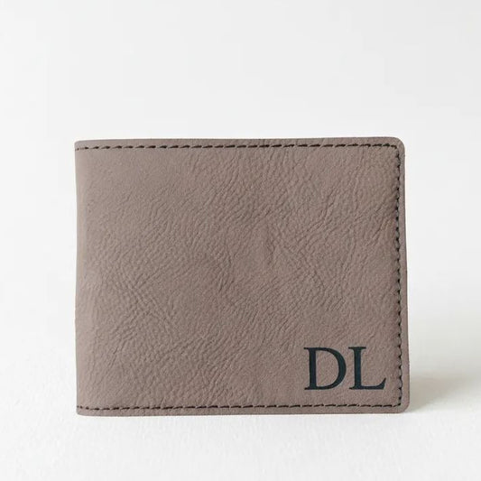 A brown leather wallet with a personalized monogrammed initials "DL" on the front.