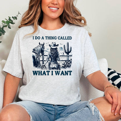 A woman wearing a white t-shirt with a graphic design of a cowboy and a cactus, along with the text "I DO A THING CALLED WHAT I WANT".