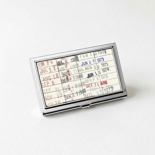 A metal card holder displaying a calendar or schedule for the months of July, August, September, October, November, and December of 1974.