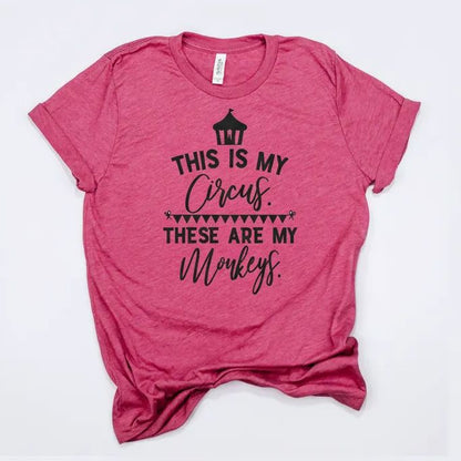 The image is a pink t-shirt with a printed text that reads "THIS IS MY CIRCUS. THESE ARE MY MONKEYS."