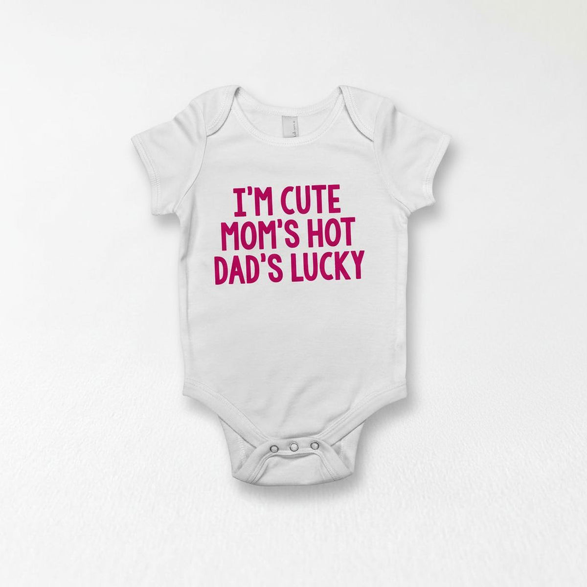 A white baby onesie with the text "I'm CUTE MOM'S HOT Dad's LUCKY" printed on it.