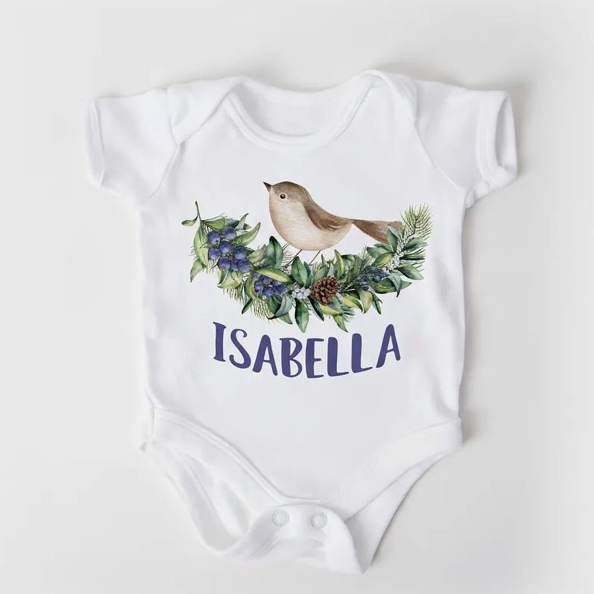 A white baby onesie with a bird illustration and the name "Isabella" printed on it.