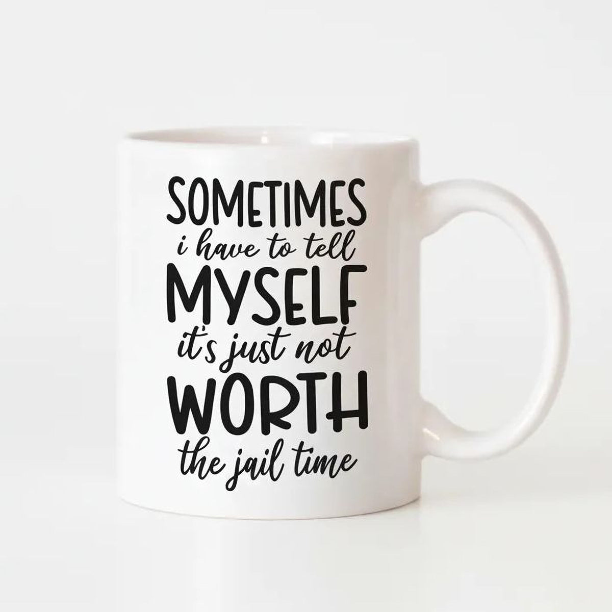 A white ceramic mug with black text printed on it.