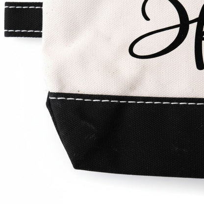 a close-up view of a black and white bag with a black zipper and a black trim.