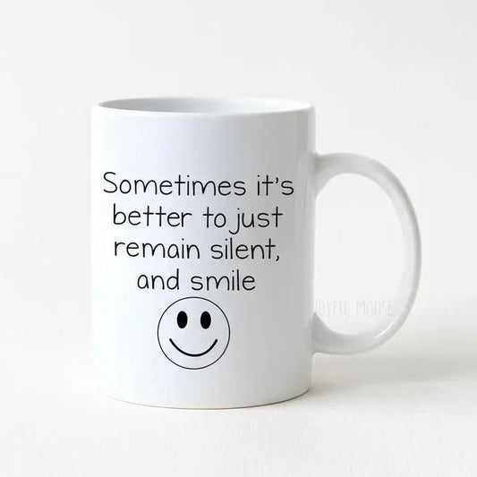 A white ceramic mug with a black smiley face and text printed on it.