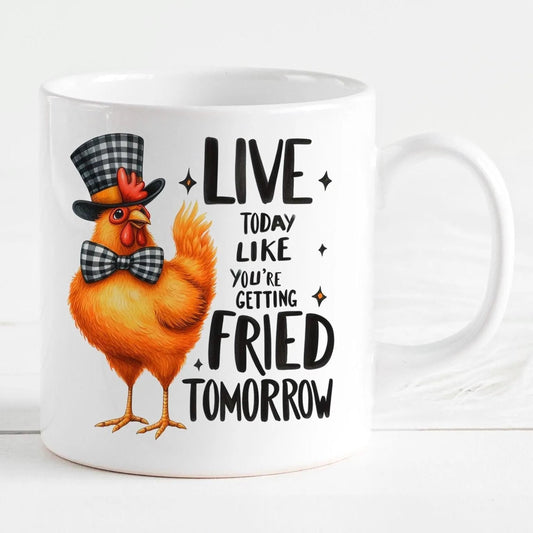 A white ceramic mug with an illustration of a chicken wearing a top hat and bow tie, along with the text "LIVE TODAY LIKE YOU'RE GETTING FRIED TOMORROW".