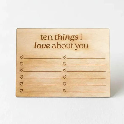 A wooden sign with the text "ten things I love about you" written on it, along with a list of hearts below the text.
