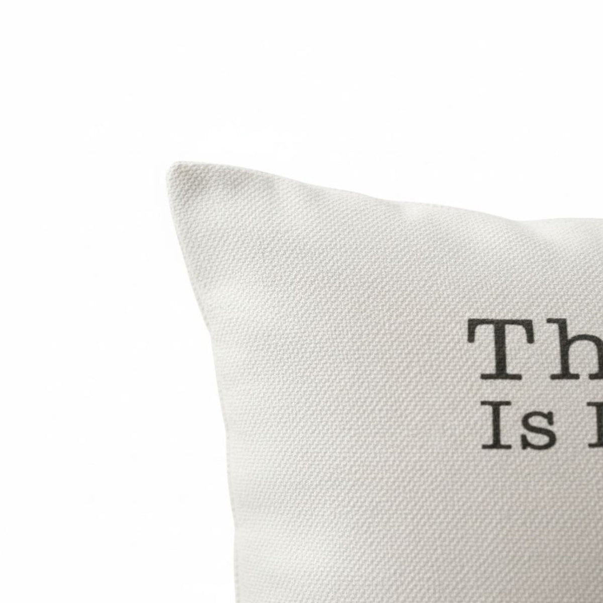 a close-up view of a white fabric, possibly a pillow or cushion, with the text "This is it" printed on it.