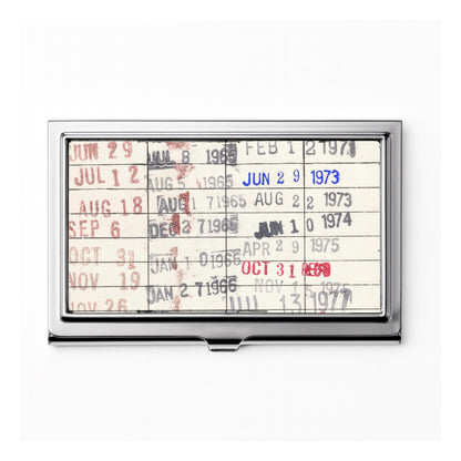 The image is a metal business card holder displaying a calendar or schedule with dates and events.