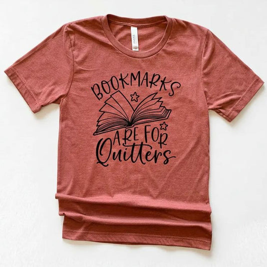 A red t-shirt with a graphic design that says "BOOKMARKS ARE FOR QUITTERS" printed on it.