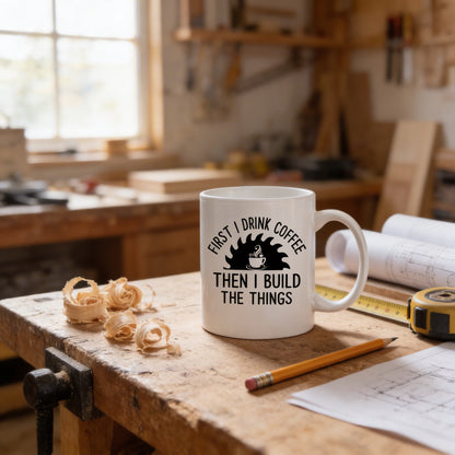 A white coffee mug with a humorous text printed on it, placed on a wooden workbench in a workshop setting.