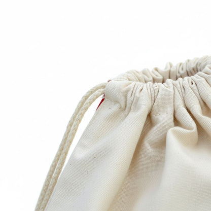A close-up view of a white drawstring bag with a red zipper, set against a plain white background.