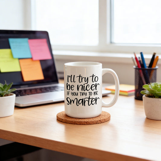 A white mug with a humorous text printed on it, placed on a cork coaster on a wooden desk. In the background, there is a laptop with sticky notes on it, and a small potted plant is visible on the desk.
