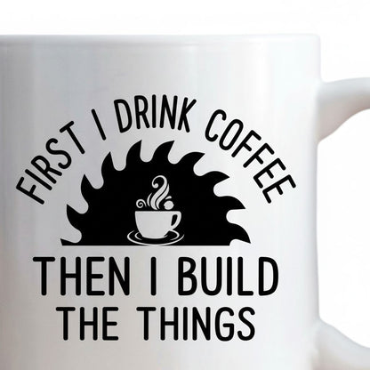 A white mug with a black and white graphic design featuring a coffee cup and a saw blade, along with the text "FIRST I DRINK COFFEE THEN I BUILD THE THINGS".